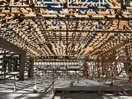 Truss deck shadows falling across the concrete slab inside a Central Florida commercial framing project