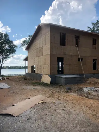 Two-story home framed and sheathed on a sandy waterfront lot